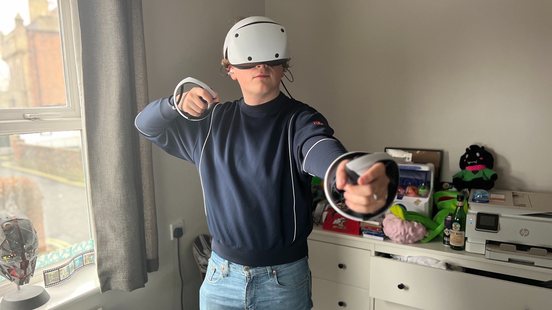 PSVR2 - Mann benutzt ein Virtual-Reality-Headset und Controller.