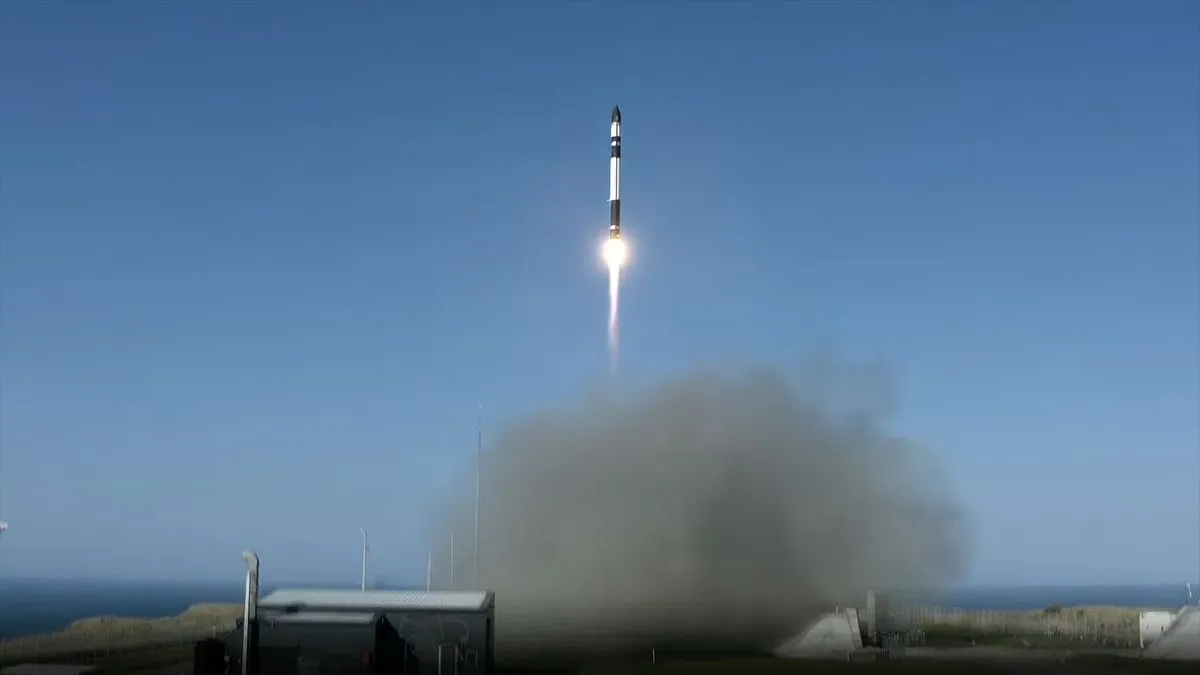 Eine weiß-schwarze Rakete steigt in einen blauen Himmel auf.